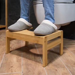 Naturfarbener Bambus Toilettenhocker mit rutschfesten Füßen, in Gebrauch vor einem WC. Unterstützt natürliche Hocksitzhaltung.