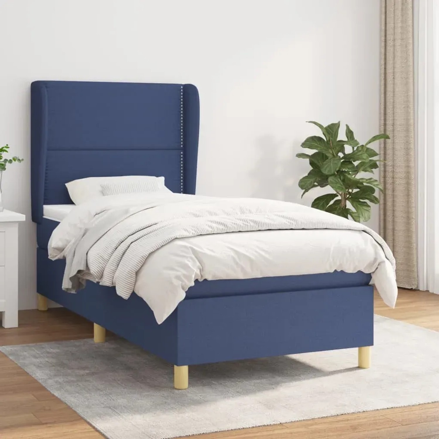 Blaues Boxspringbett (90x200 cm) mit Matratze und Stoffbezug. Bett mit hohem Kopfteil.