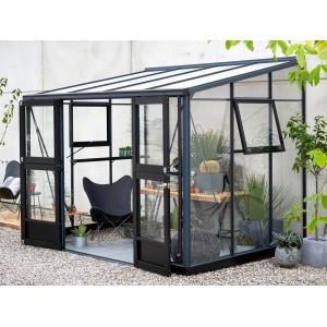 Juliana Gewächshaus Veranda 6 Anthrazit: Anlehngewächshaus mit Glas und Aluminiumrahmen, eingerichtet mit Pflanzen und Möbeln.