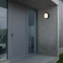 Schwarze Brilo Akku Außenwandleuchte Pula mit Bewegungsmelder an Hauswand.