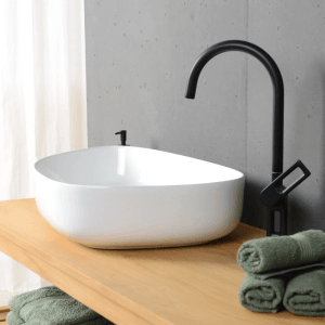 Weißes, glänzendes Keramik Aufsatzwaschbecken (55 cm) von Wohnfreuden auf Holzplatte mit Armatur.