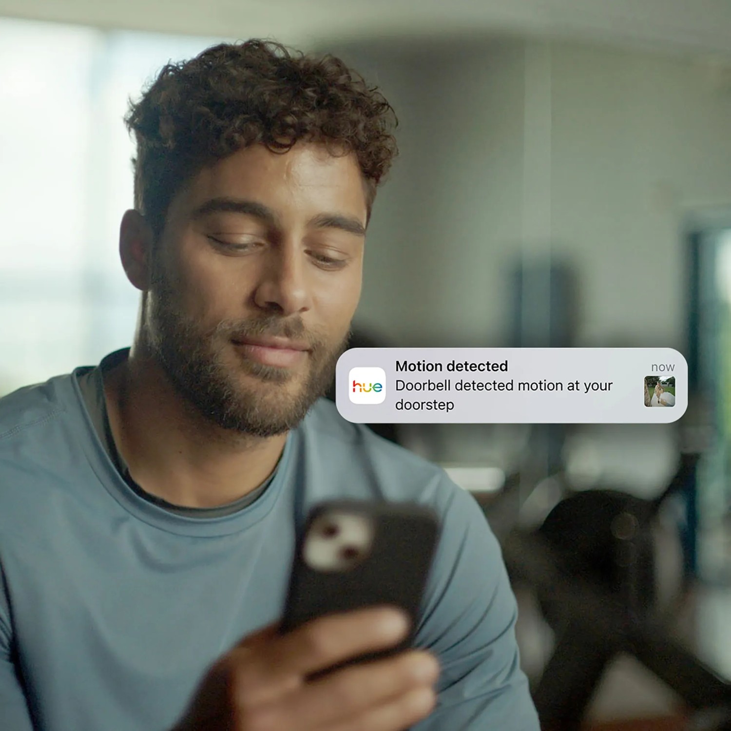 Mann erhält Benachrichtigung der Philips Hue Türklingelkamera auf seinem Smartphone.