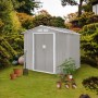Hattoro S100 Metall Gerätehaus, hellgrau, mit Satteldach und Doppeltür, im grünen Garten mit Pflanzen.