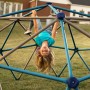 Kind spielt auf Lifetime Klettergerüst Geodome, blau-graue Kletterkugel für den Garten.
