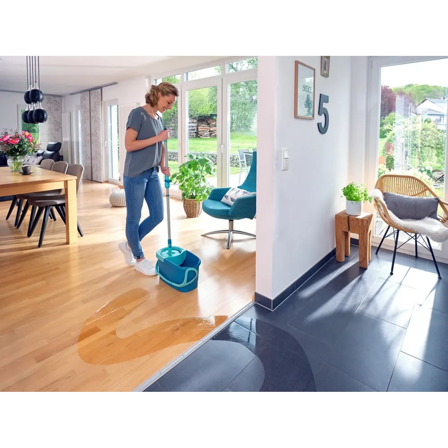 Frau wischt Holzboden mit Leifheit Clean Twist Disc Mop Ergo Reinigungsgerät.