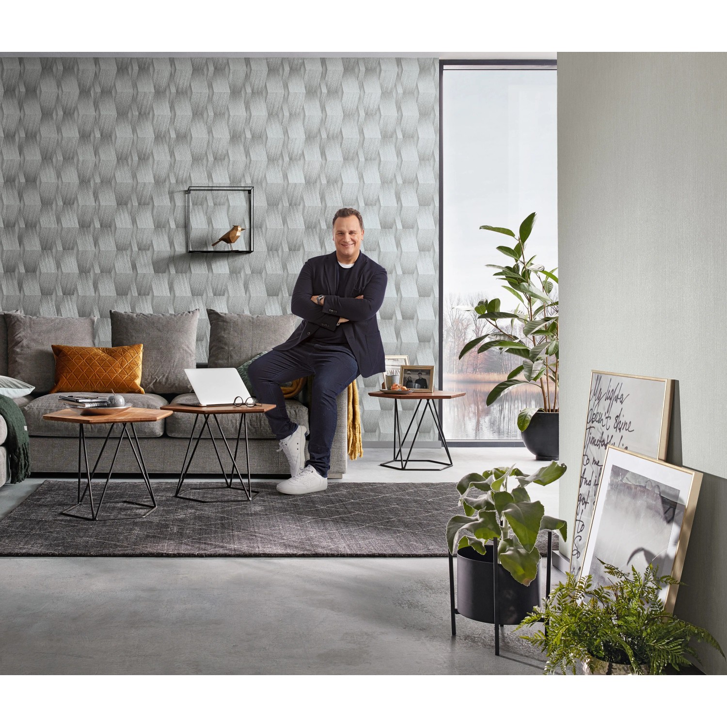 Wohnzimmer mit grauer Erismann Vliestapete Guido Maria Kretschmer Fashion for Walls Grafik.