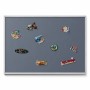 Graue Tulup Magnettafel 100x70 cm mit silbernem Rahmen, dekoriert mit bunten Reisemagneten. Ideal für Notizen & Fotos.