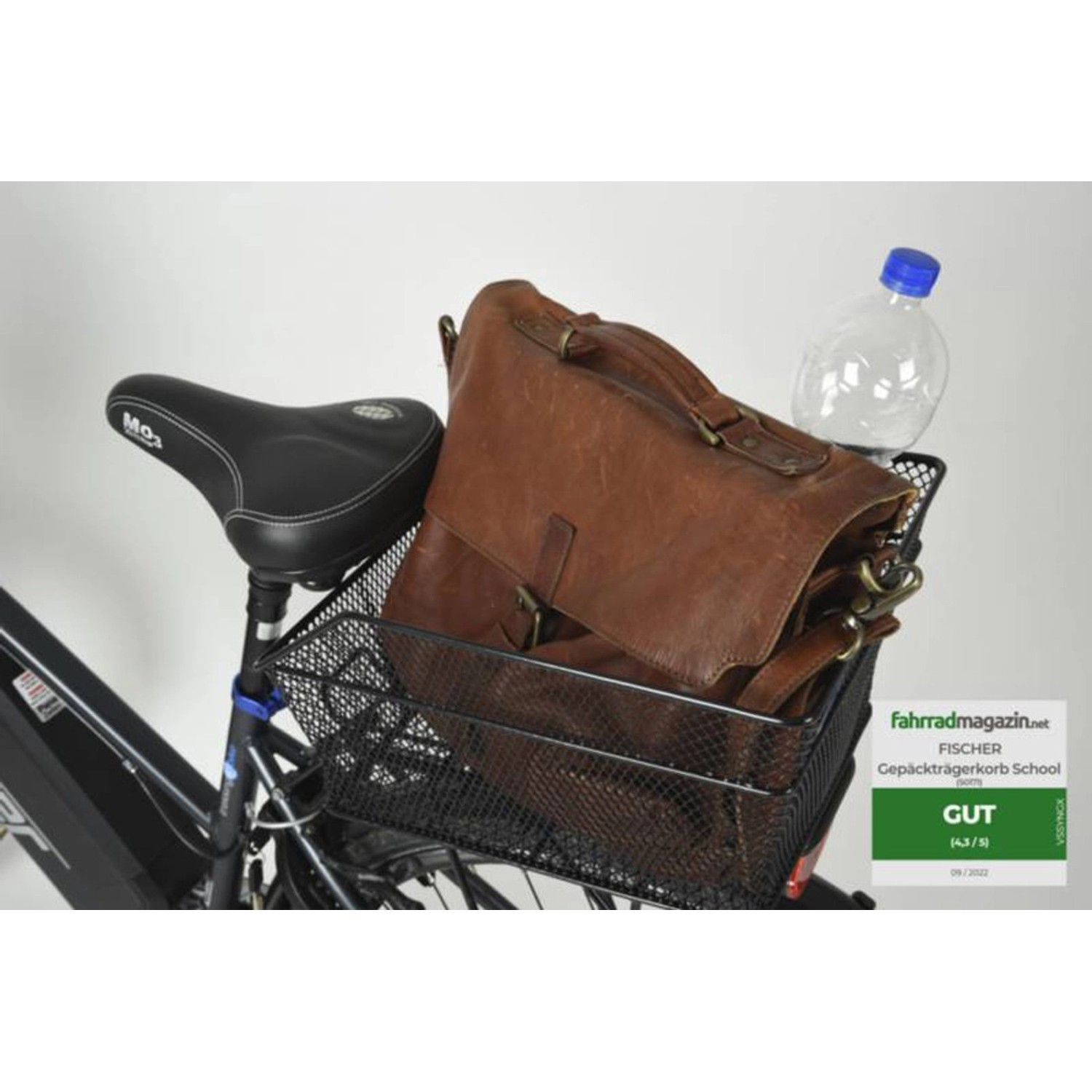 Schwarzer Fischer Fahrrad-Gepäckträgerkorb School mit Tasche und Flasche auf einem Fahrrad.