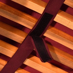 Rotes Befestigungsband der Beautissu Deckchairauflage mit Klettverschluss auf Holzlatten. Sichert die Auflage am Gartenstuhl.