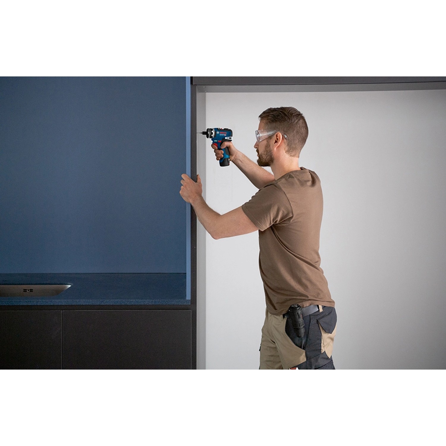 Handwerker mit Bosch Professional Bohrhammeraufsatz GFA 12-H FlexiClick beim Bohren.