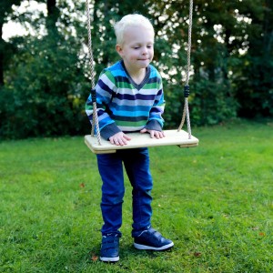 Kind auf AXI Holz Schaukelsitz im Garten. Schaukel für Schaukelgerüst oder Spielturm.