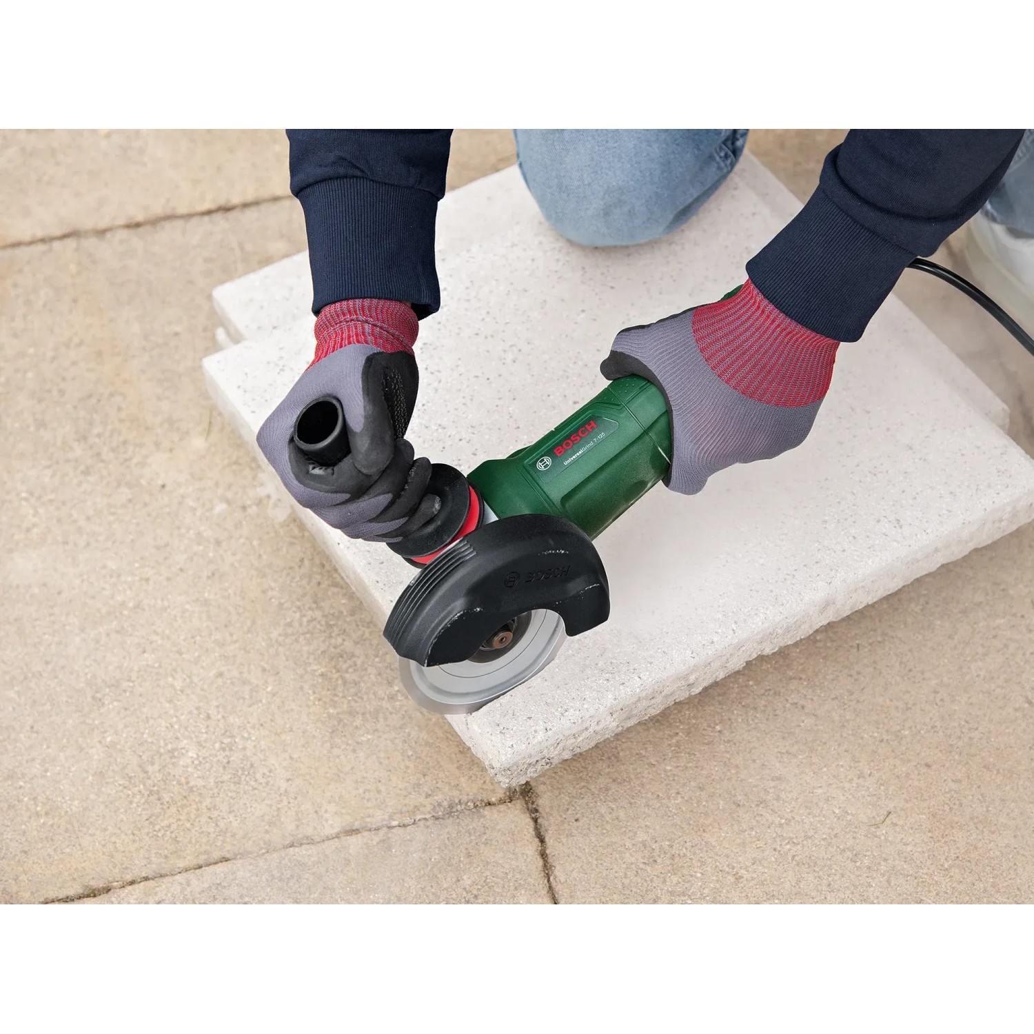 Bosch UniversalGrind 850-125 Winkelschleifer im Einsatz beim Schleifen einer Steinplatte.