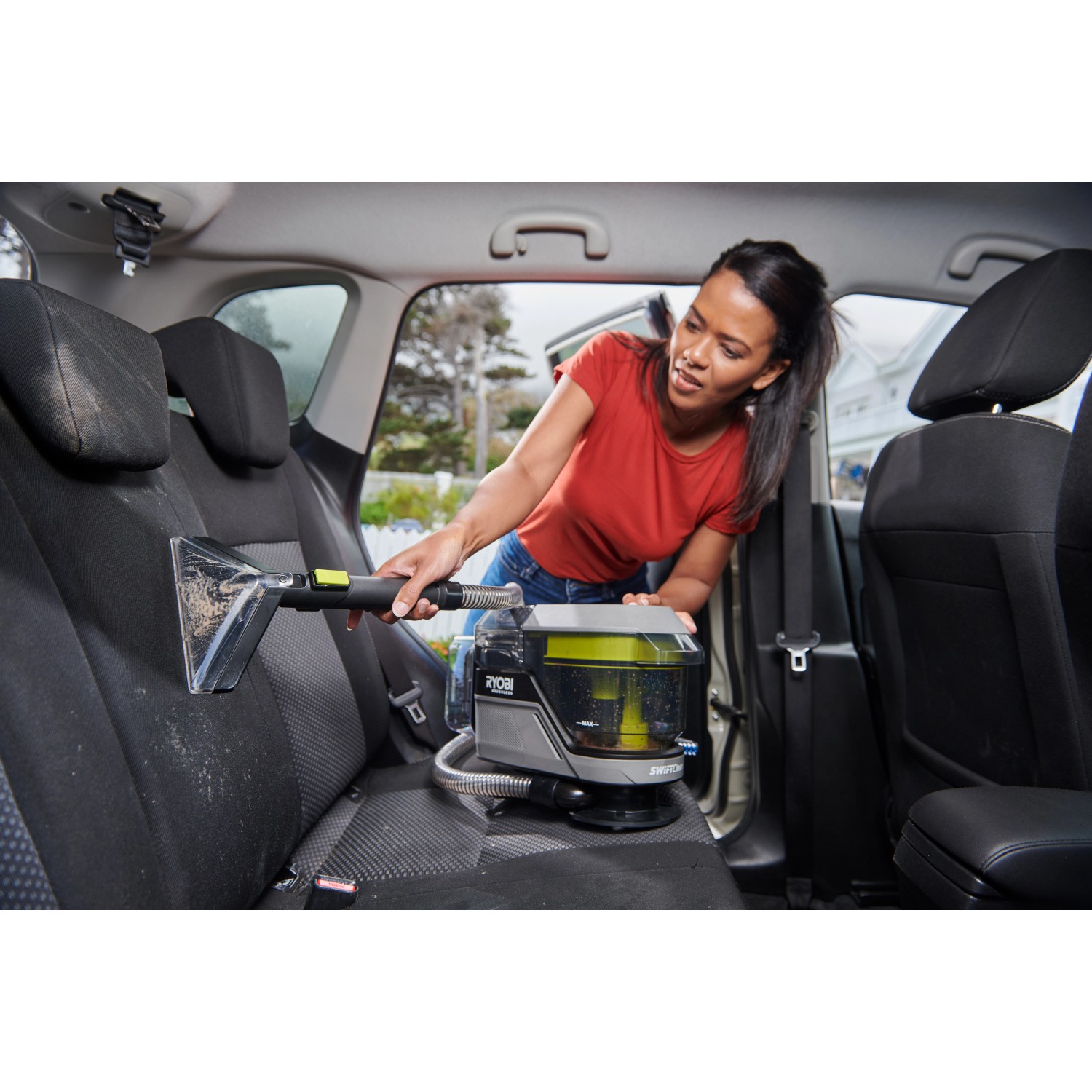 Frau reinigt Autositz mit Ryobi Akku-Textilreiniger Pro One+ 18V.