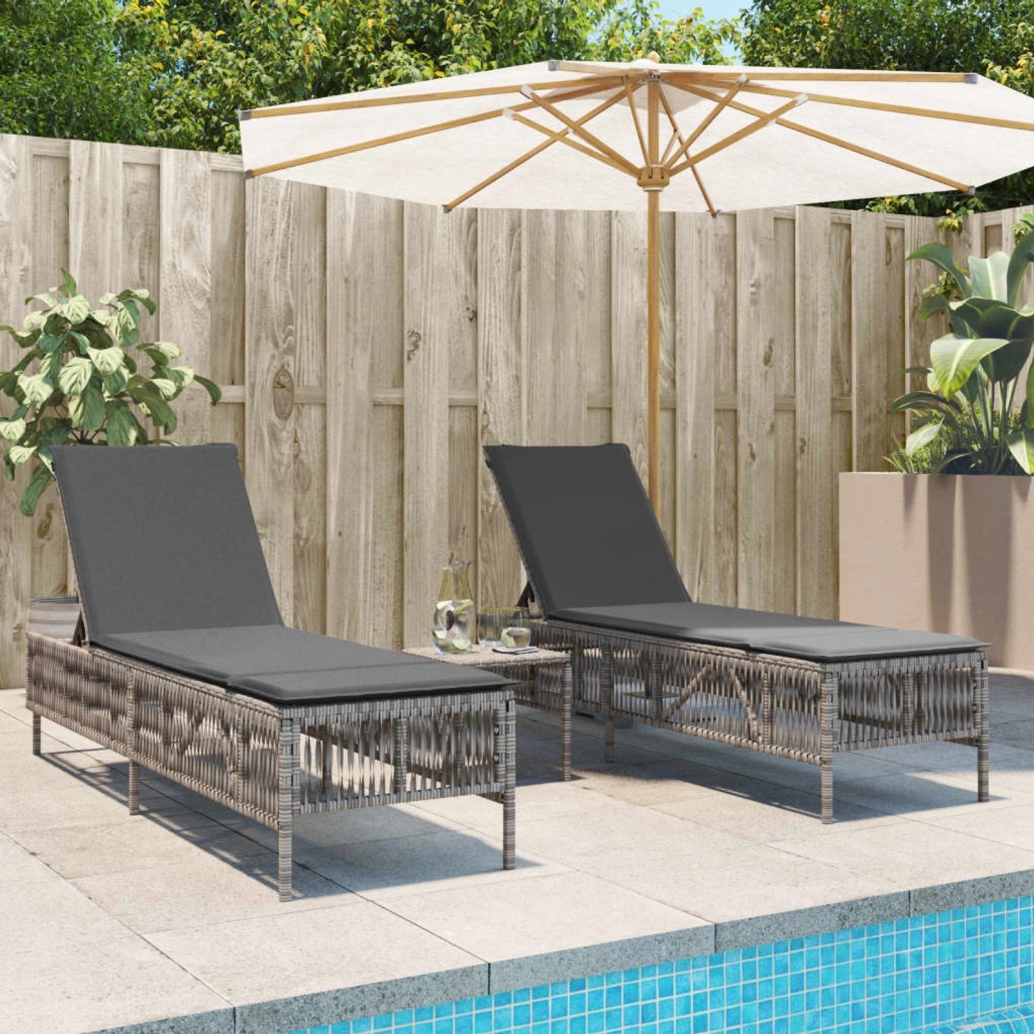 Zwei graue Poly Rattan Sonnenliegen mit Auflagen am Pool. Entspannung pur!