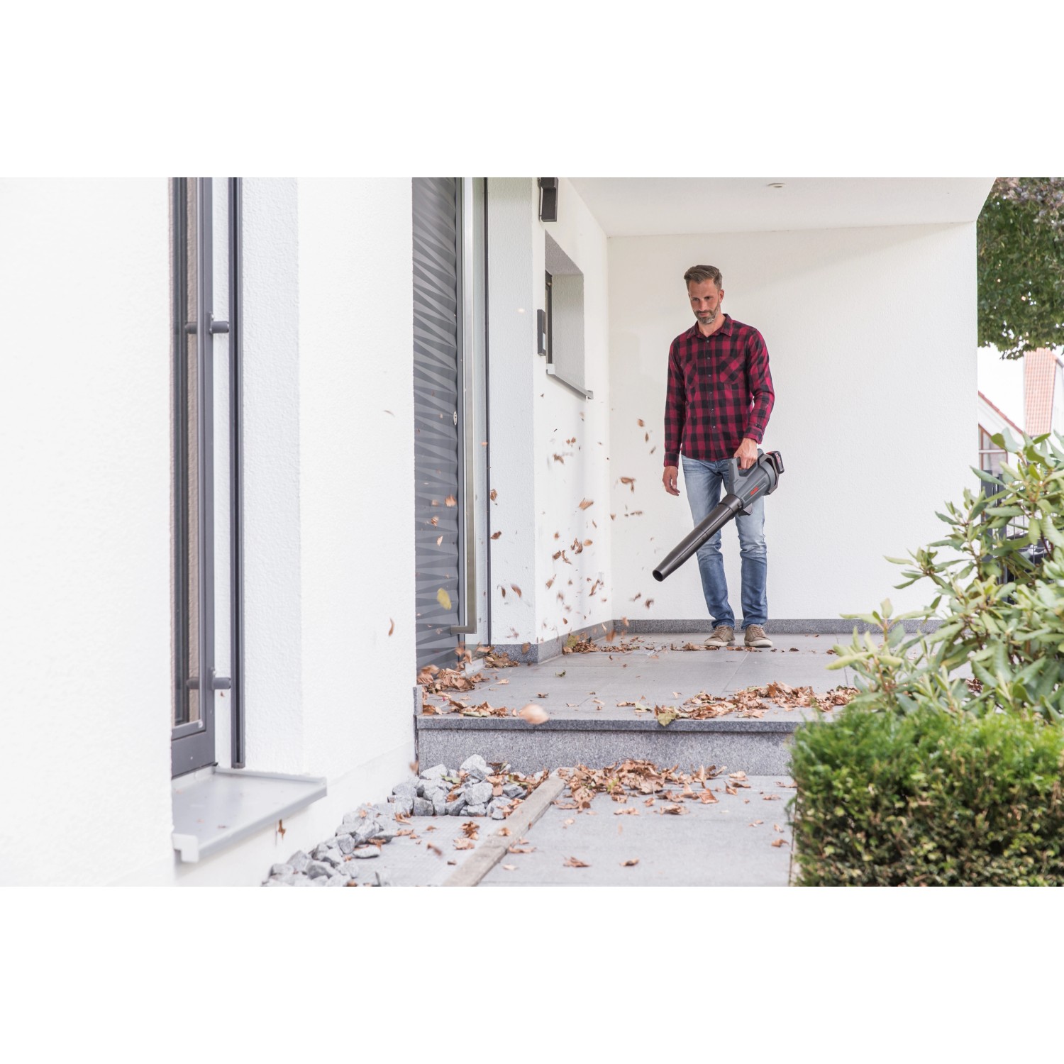 Mann benutzt Al-Ko Akku-Laubbläser LB 1860, um Laub zu entfernen. Inkl. 18V Akku, kompatibel mit Bosch.