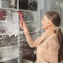 Frau reinigt Fenster mit Vileda Profi Fensterwischer Set mit Stiel.