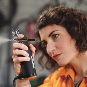 Frau benutzt Worx MakerX Akku-Airbrush WX742.9 Sprühgerät für feine Detailarbeiten.