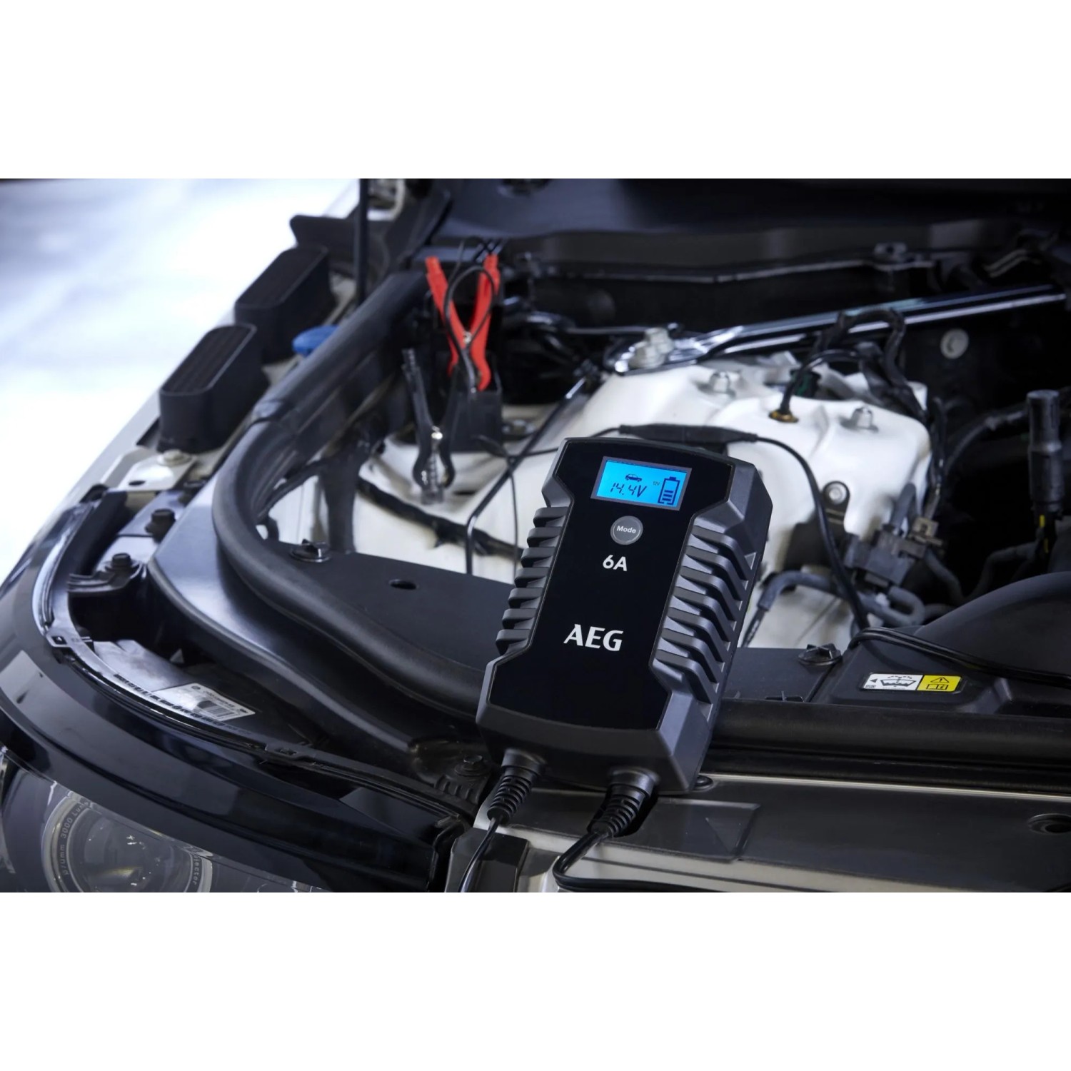 AEG Mikroprozessor-Ladegerät LD 6 A beim Laden einer Autobatterie unter der Motorhaube.