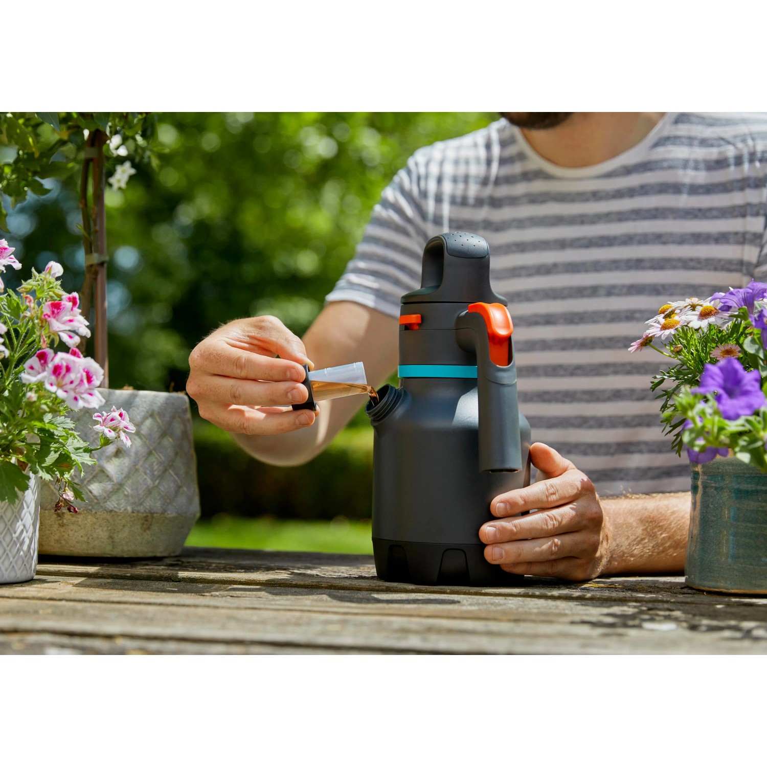 Gardena Drucksprüher 1,25 l beim Befüllen auf einem Gartentisch.