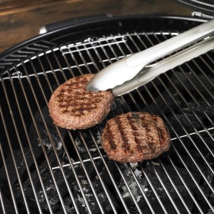 Rösle Grillzange (40 cm) aus Edelstahl wendet Burger auf Grill.