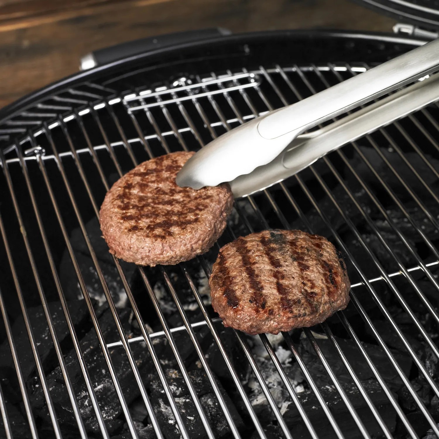 Rösle Grillzange (40 cm) aus Edelstahl wendet Burger auf Grill.