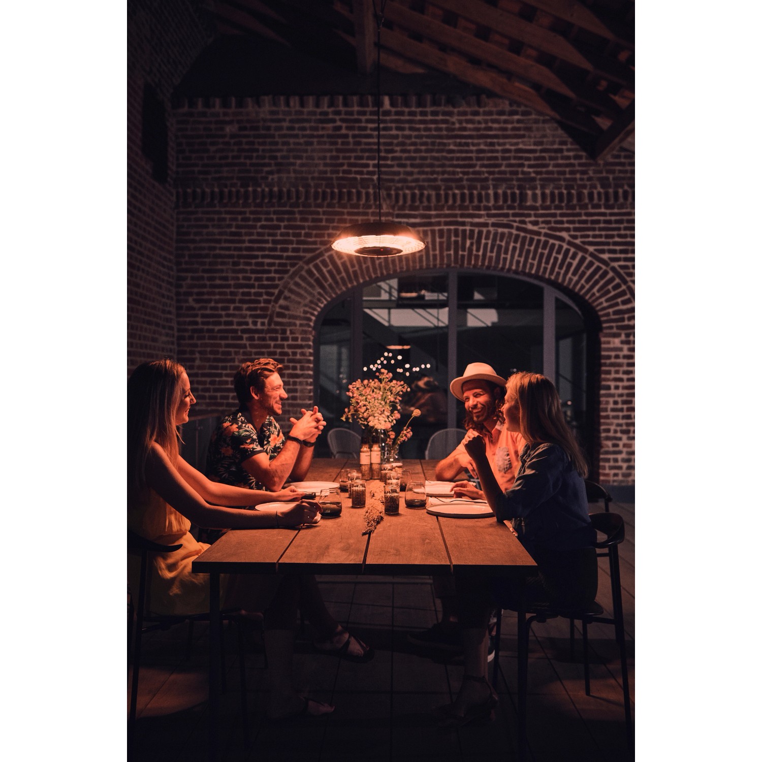 Enders Marbella Deckenstrahler spendet Wärme über einem Esstisch mit vier Personen im Außenbereich.