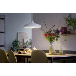 Philips LED-Lampe E27, ultraeffizient, 7,3W, in Glühlampenform unter weißer Hängelampe über Esstisch.