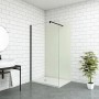 Begehbare Dusche mit elfenbeinweißer Duschwand (120x210cm) und schwarzem Rahmen vor weißer Wand.