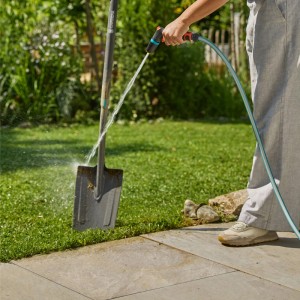 Gardena Reinigungsspritze Classic im Einsatz: Eine Person reinigt eine Schaufel mit der Gartenspritze.