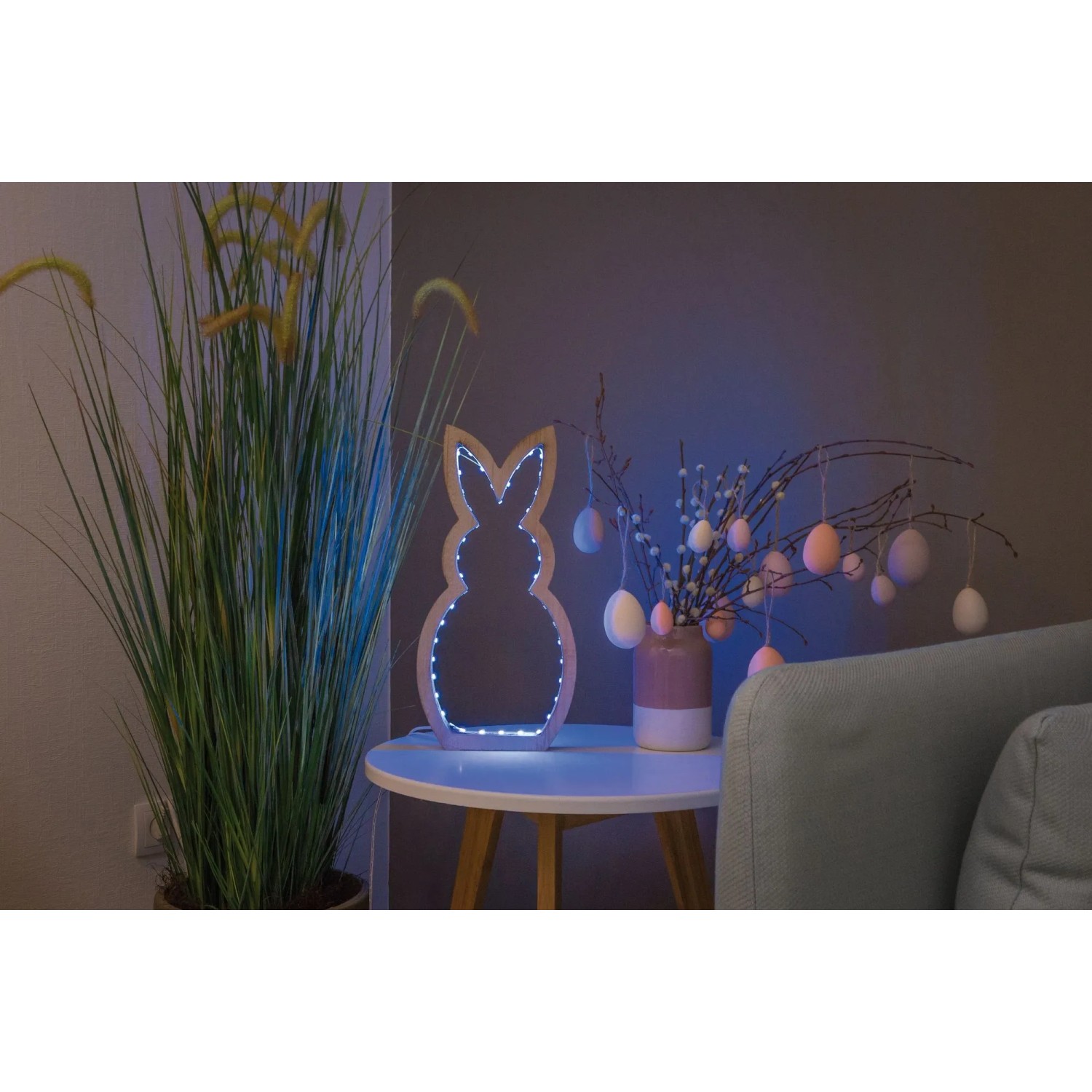 Dekorative Hasen-Leuchte mit LED-Streifen auf Tisch, umgeben von Osterdekoration.