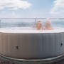 MSpa Lite Glow AirJet aufblasbarer Whirlpool mit Hydromassage, genutzt von Paar auf Holzterrasse.