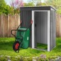 Grüne ECD Germany Gartenschubkarre (100L) mit Luftrad an Gartenhauswand.