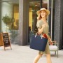 Rotho Multibag Albula Style 25 l Dunkel-Blau, getragen von einer Frau in der Stadt.