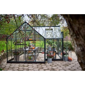 Halls Gewächshaus Icon Gardenhouse 8, 13 m², grüne Rahmen, mit Pflanzen und Tisch im Garten.