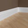 Weißes Sockelleisten Set (10 Stk.) von PROFHOME, montiert an einer braunen Wand über einem hellen Holzboden.