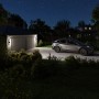 Eufy Wandleuchte mit Kamera S100 beleuchtet Hofeinfahrt mit Auto bei Nacht.