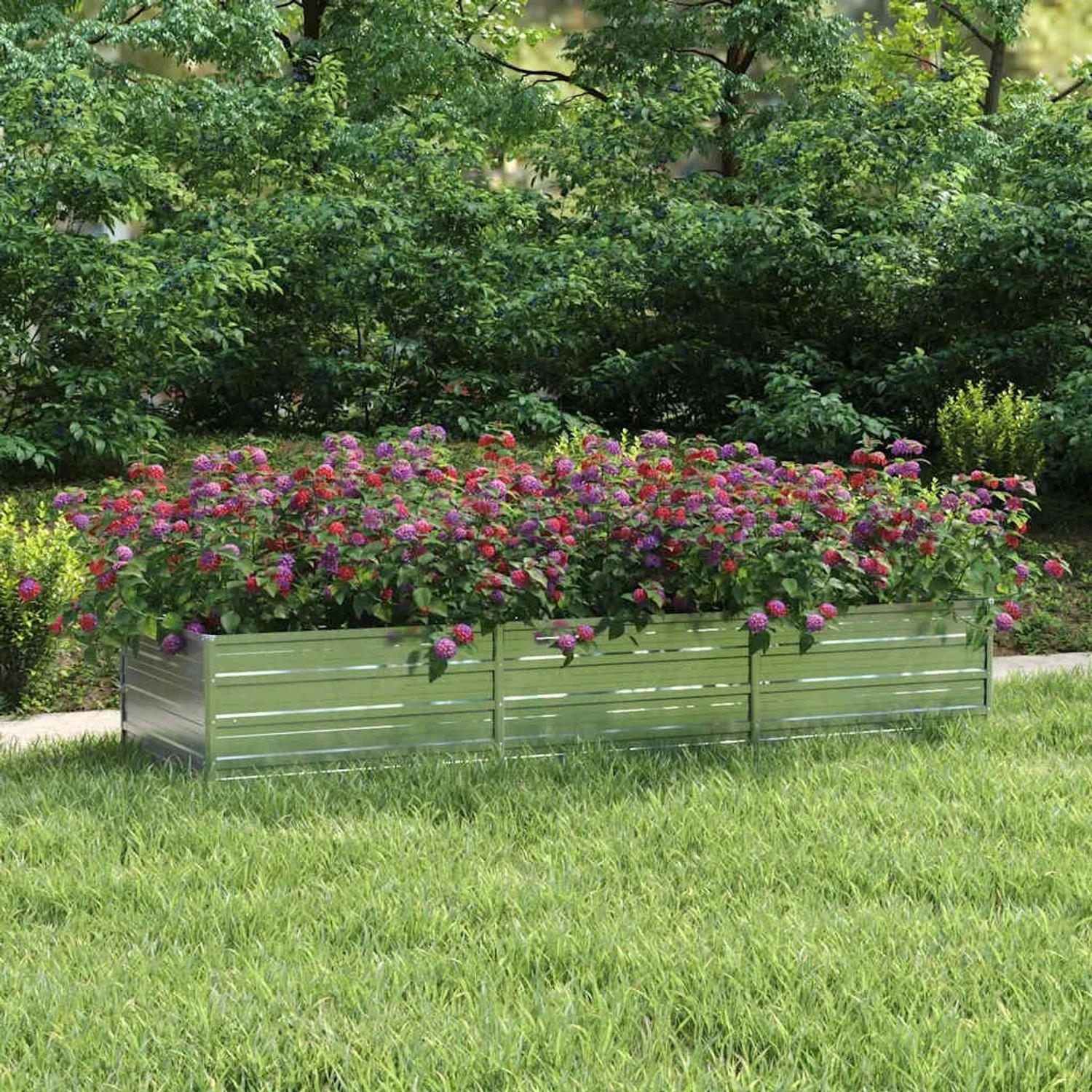 Silbernes Furnicato Garten-Hochbeet (240x80x45 cm) aus verzinktem Stahl, bepflanzt mit bunten Blumen.