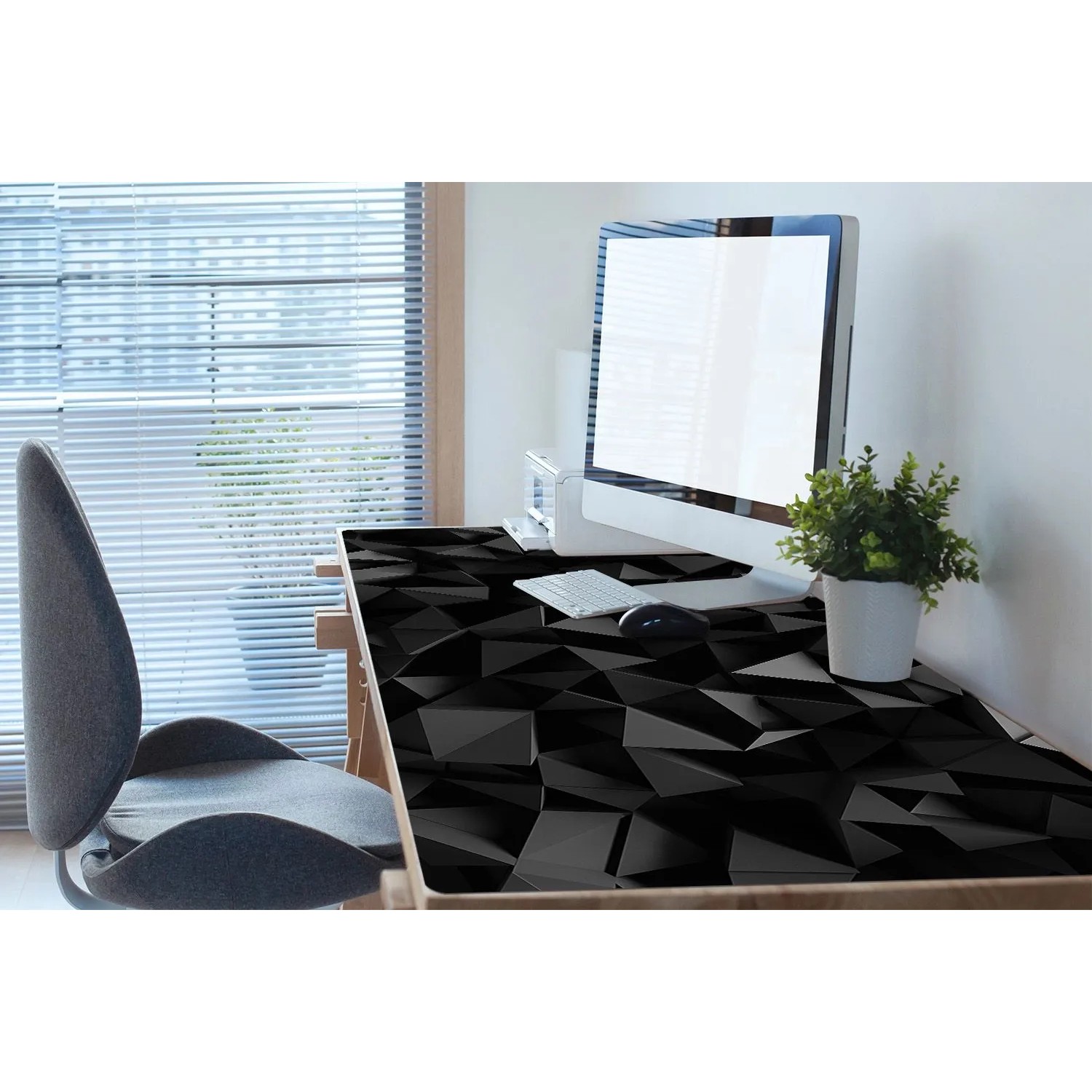 Schwarze Tulup Schreibtischunterlage mit abstraktem Muster auf einem Schreibtisch mit PC.