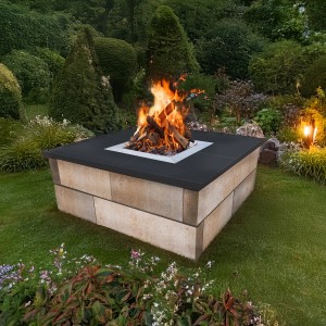 EHL CityPur Feuerstelle mit Tribus-Set aus Sandstein, 73x73x41cm, mit brennendem Holz im Garten.