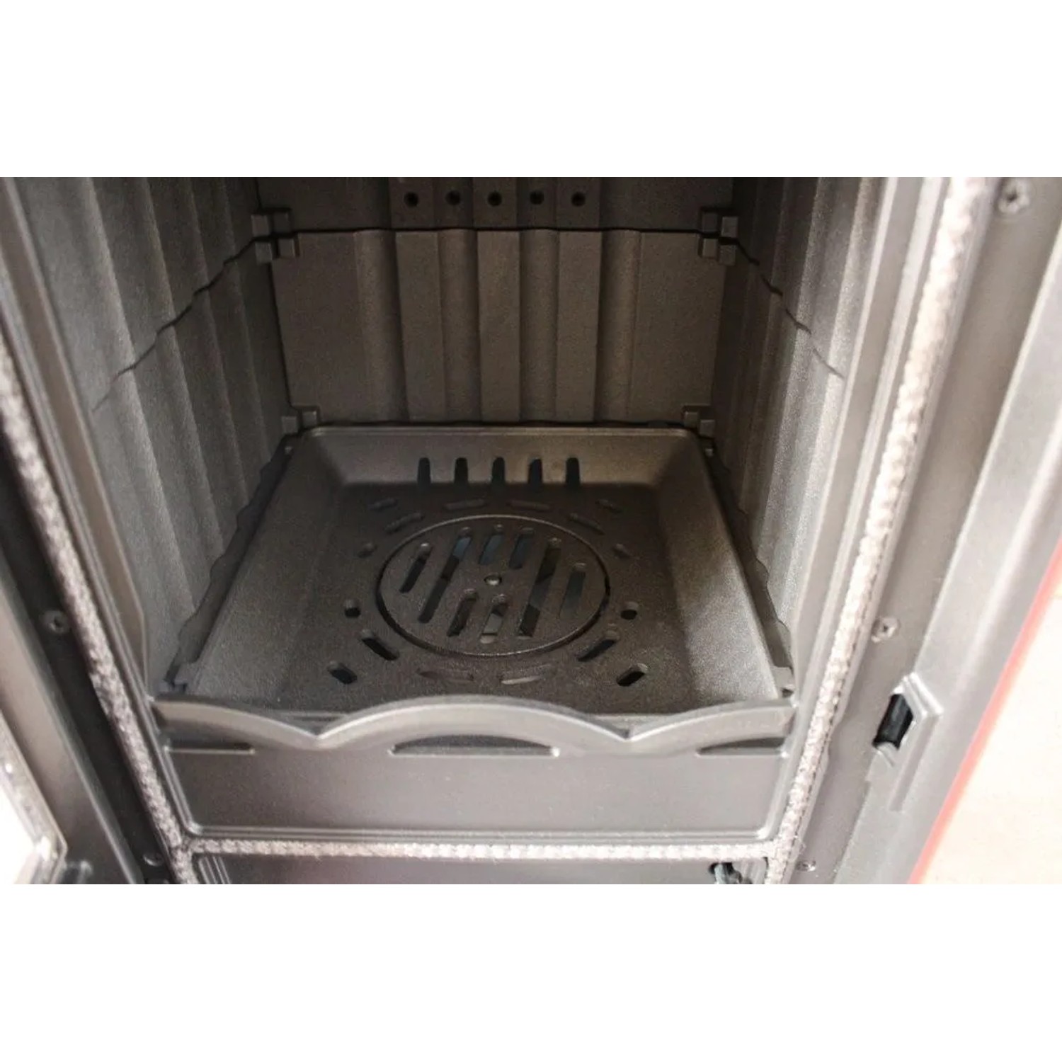 Robuster Gusseisen-Brennraum des Plamen Maestral N Kaminofens mit Rost und Aschekasten.