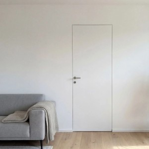 Weißes, wandbündiges Tür-Komplettset SecretLine (88,5x201 cm) in Wohnraum mit Sofa.