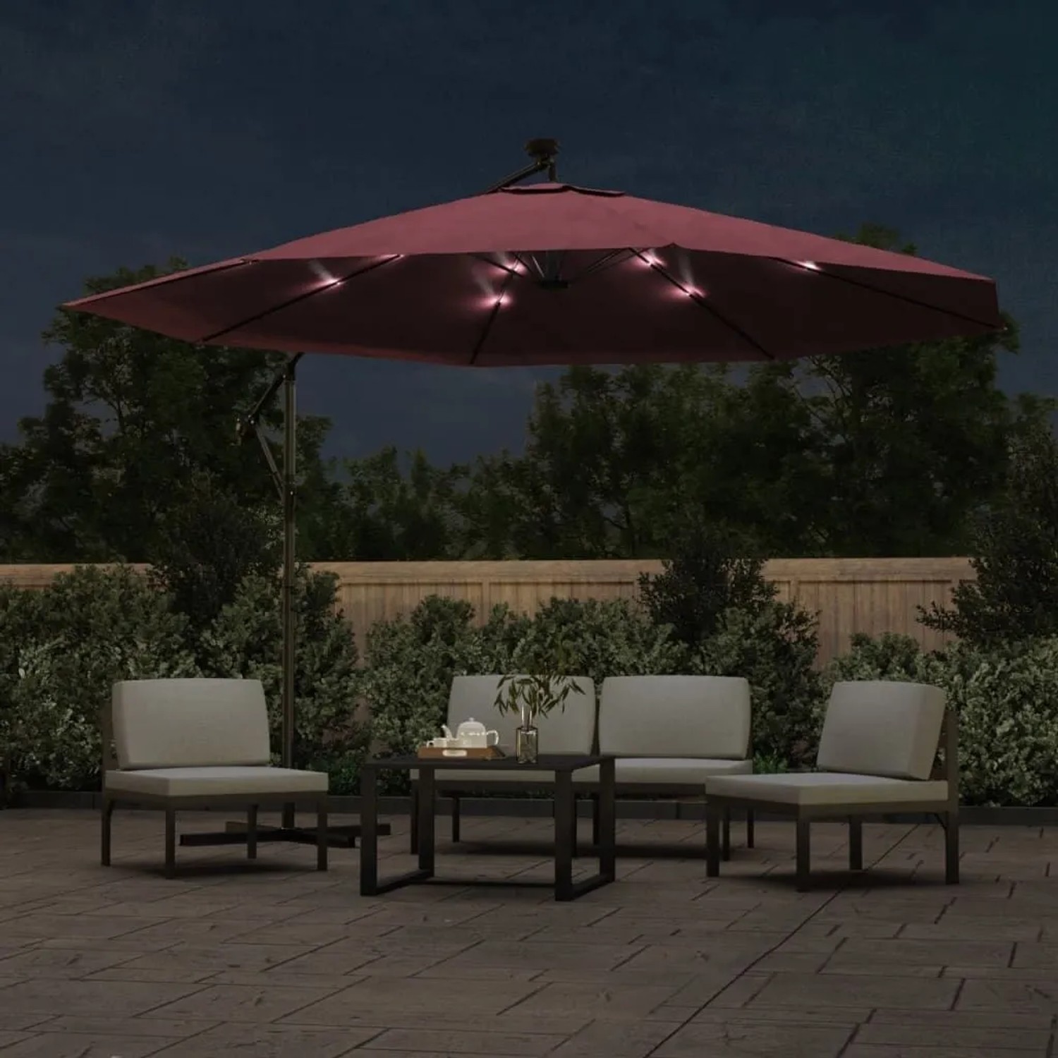 Bordeauxroter Ampelschirm mit leuchtender LED-Beleuchtung auf Terrasse am Abend. 350 cm Sonnenschirm mit Stahl-Mast für Garten.