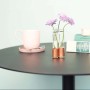 DIY Kupfervase von CREATE! by OBI mit lila Blumen auf schwarzem Tisch.
