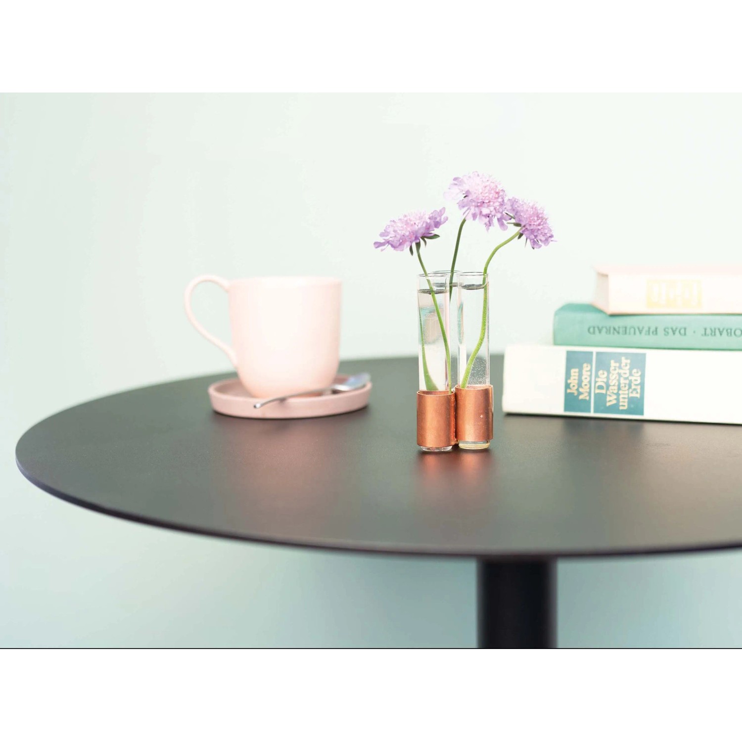 DIY Kupfervase von CREATE! by OBI mit lila Blumen auf schwarzem Tisch.