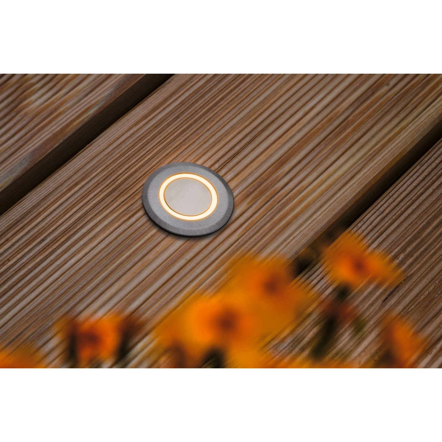 Runder Paulmann LED-Bodeneinbaustrahler für den Außenbereich, insektenfreundlich, auf Holzterrasse.