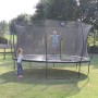 Grünes EXIT Silhouette Trampolin D305cm mit Sicherheitsnetz und Kindern im Garten.