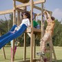 Axi Spielturm Moos mit Doppelschaukel, Rutsche blau, Strickleiter und Kletterwand. Kinder spielen im Garten.