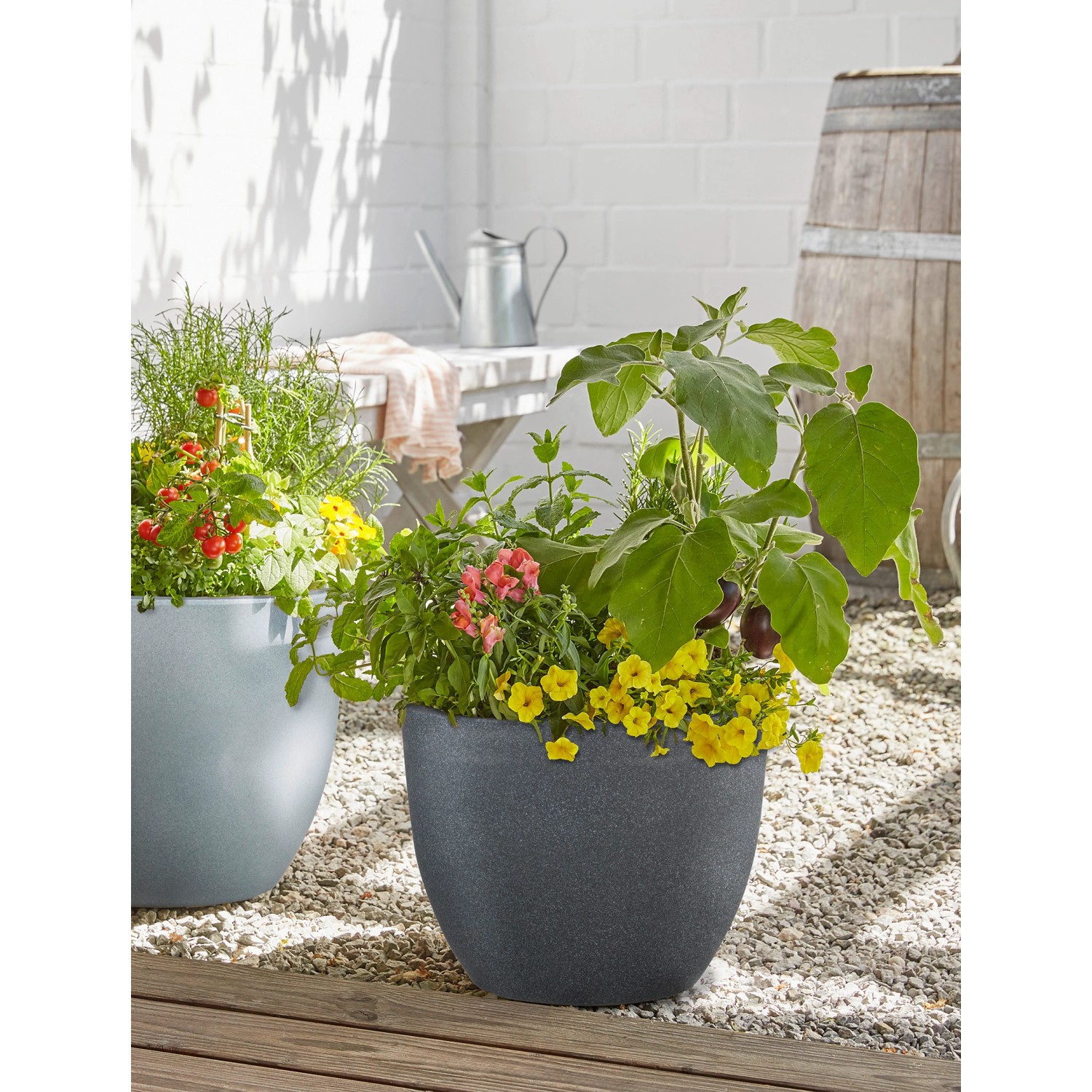 Scheurich Pflanzgefäß Padua, Ø 29,8 cm, Schwarz Granit, bepflanzt mit bunten Blumen.