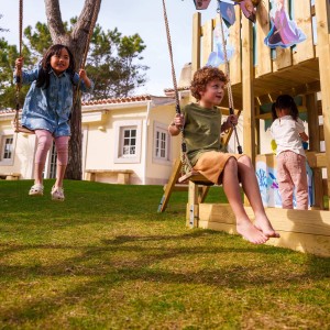 Kinder spielen auf dem pastellblauen Wickey Disney Adventure Spielturm mit Rutsche im Garten.
