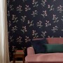 Joules Vliestapete Swanton Floral in Marineblau mit Blumenmuster, kombiniert mit Sofa und Deko.